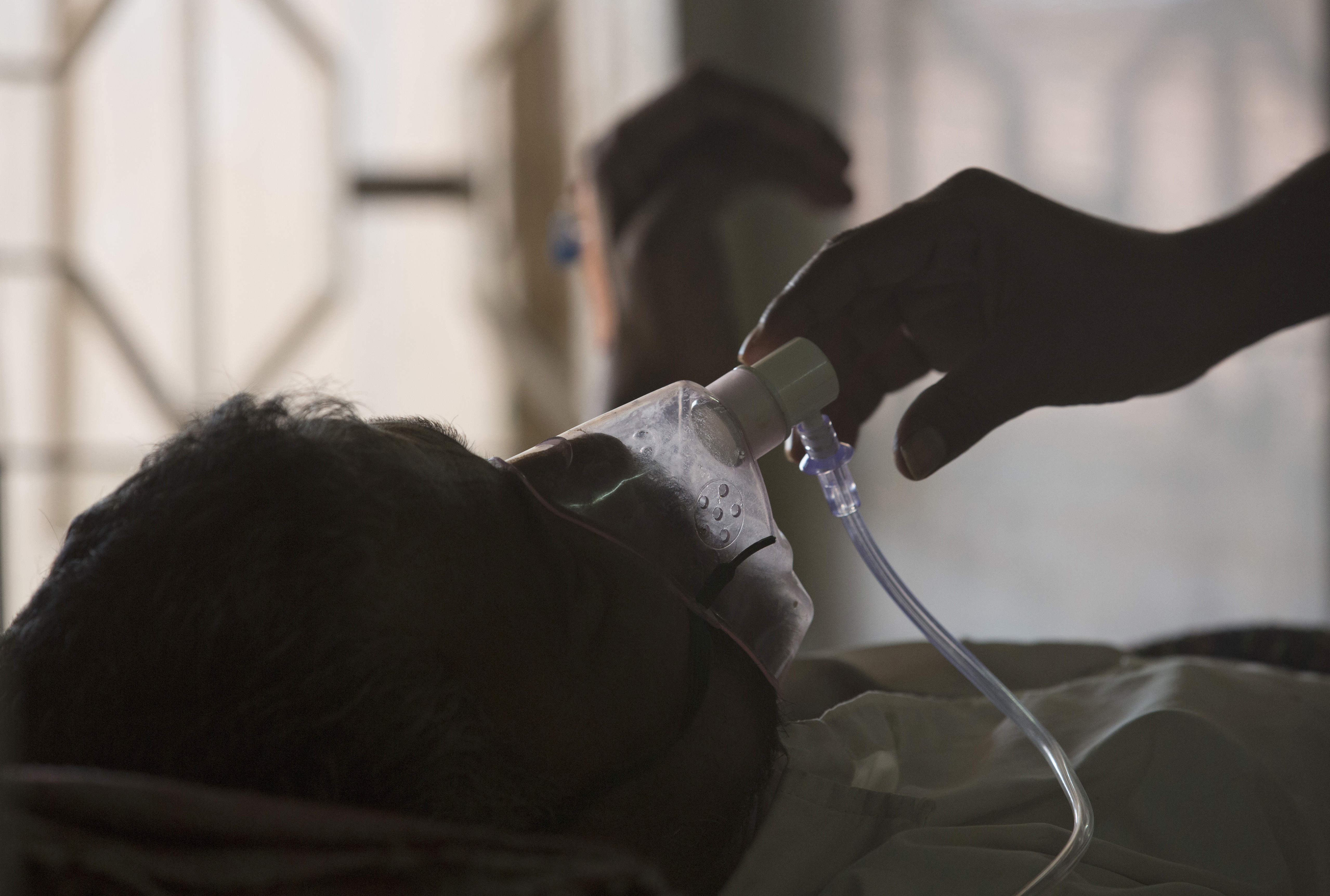 A relative adjusts the oxygen mask of a tuberculosis patient at a TB hospital on World Tuberculosis Day in Hyderabad, India, March 24, 2018.
