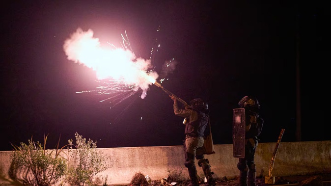 Riot police fire tear gas at a group of protesters as they block several sections of a highway in the province of Veraguas, Panama. Photo / AFP