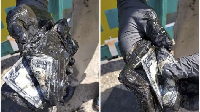 Magnet fisher James Kane displays the part of the contents of a safe he pulled out of a pond, in Flushing Meadows Corona Park, in the Queens borough of New York. Photo / AP