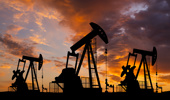 Oil field with rigs and pumps at sunset. World Oil Industry - stock photo