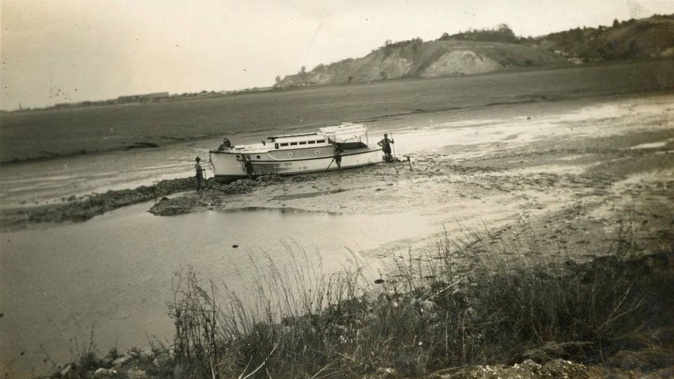 Four men try to refloat their boat in what was the Ahuriri lagoon after the 1931 Hawke’s Bay earthquake emptied it of most of its water. Photo / Keith Winks