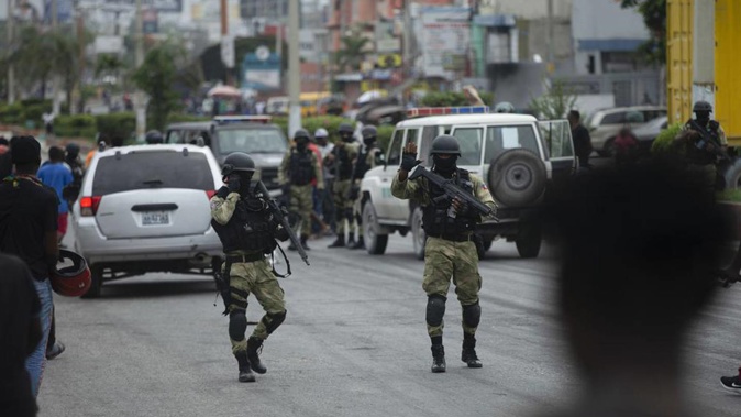 Police attempt to secure an area past a roadblock set up by taxi drivers protesting fuel shortages, in Port-au-Prince, Haiti. (Photo / AP)