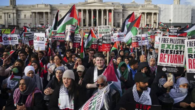 Protesters hold placards and Palestinian flags during a pro-Palestinian rally in Trafalgar Square, London. Photo / AP