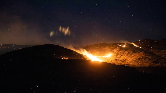 Homes have been evacuated as firefighters battle a large vegetation fire near Waipara. Photo / George Heard
