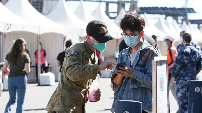 A member of the Australian Defence Force assists people arriving at the Qudos Bank Arena NSW Health Vaccination Centre on August 16, 2021 in Sydney. (Photo / Getty Images)