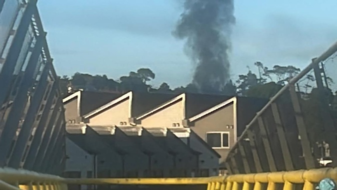 Smoke rises over Westgate in West Auckland after a fire this morning. Photo / Rita Elaine