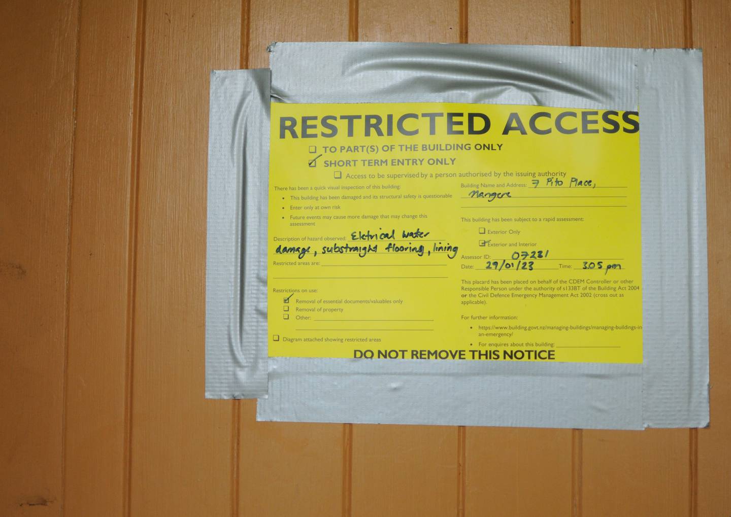 The yellow sticker on the front of a Pito Place home outlining the damage to the property caused by the flooding on January 27. Photo / Stephen Forbes, Stuff