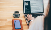 Woman writing resume on laptop. - stock photo