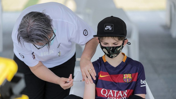 Liam Williams aged 12 years being vaccinated for Covid-19 at the Got Ya Dot event at Eden Park. Photo / Michael Craig.