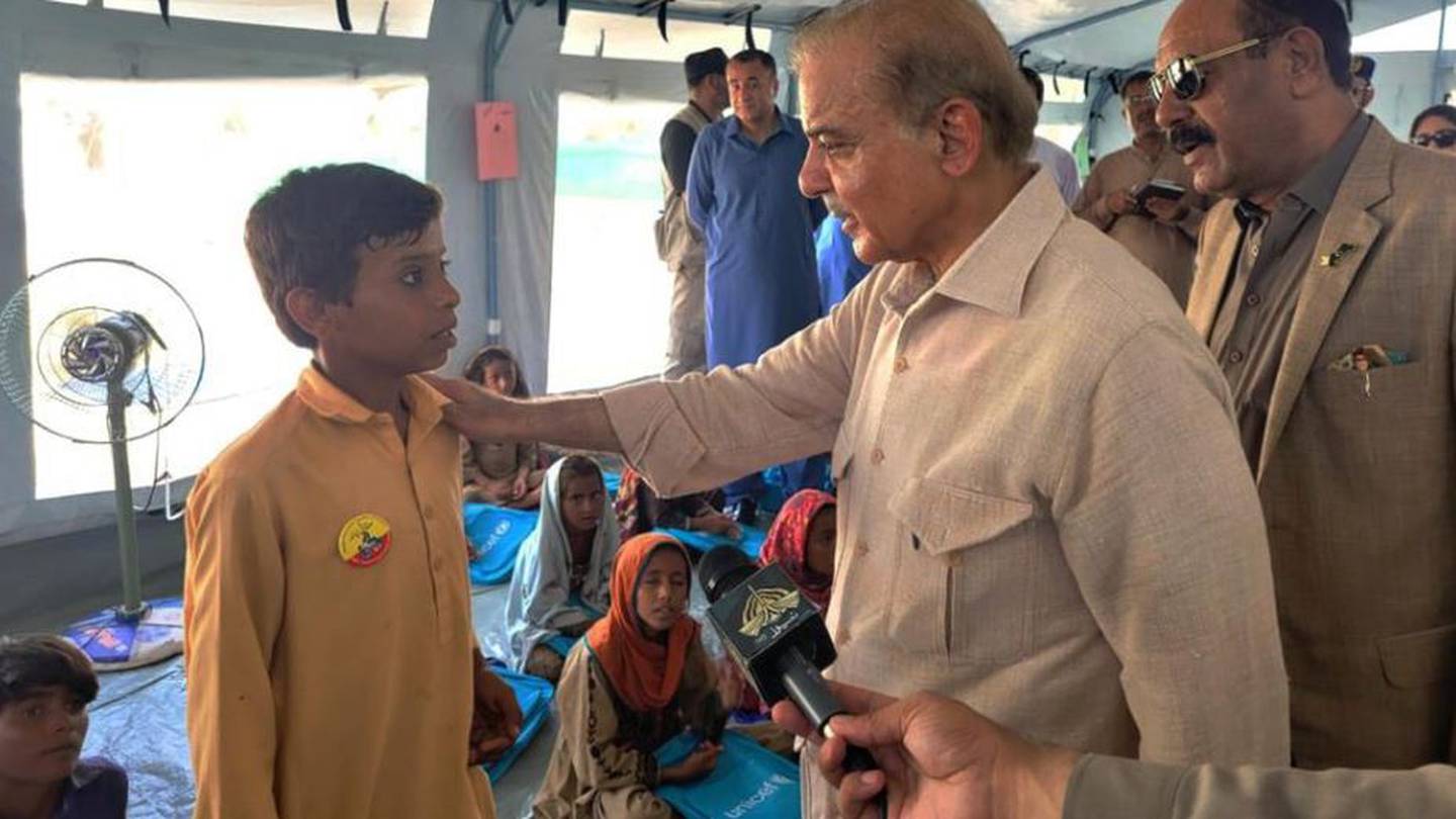 Prime Minister Shahbaz Sharif talks to a student at a makeshift school inside a tent in the flood-hit area of Suhbatpur in Baluchistan. Photo / AP