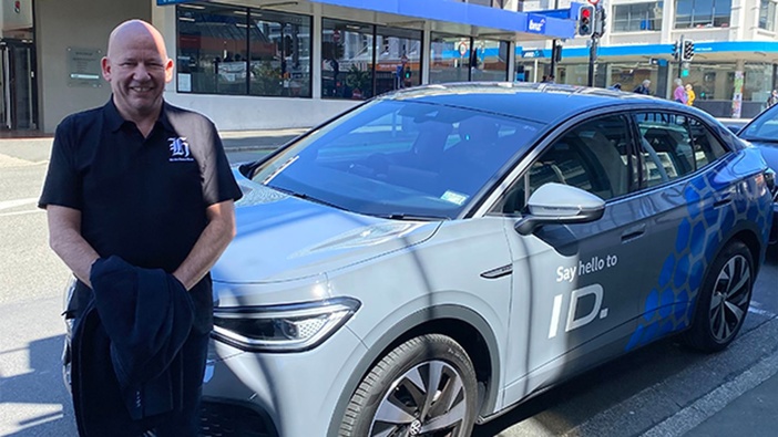 NZ Herald's editor at large Shayne Currie with his trusty VW ID.5, outside of The Country HQ in Dunedin. (Photo / Jamie Mackay)
