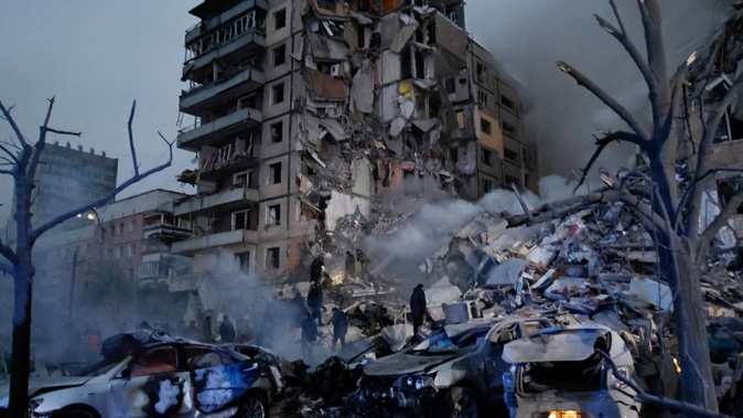 Emergency workers clear the rubble after a Russian rocket hit a multi-storey building leaving many people under debris in Dnipro, Ukraine. Photo / AP