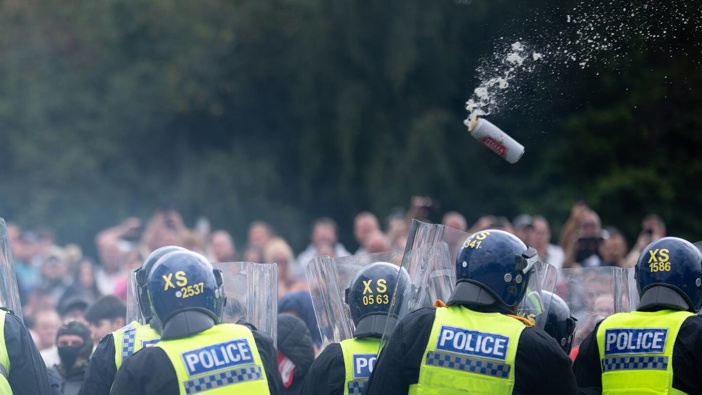 Riot police officers push back anti-migration protesters outside the Holiday Inn Express Hotel in Rotherham, United Kingdom. Photo / Getty Images
