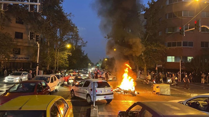 In this photo taken by an individual not employed by the Associated Press and obtained by the AP outside Iran, a police motorcycle burns during a protest. Photo / AP