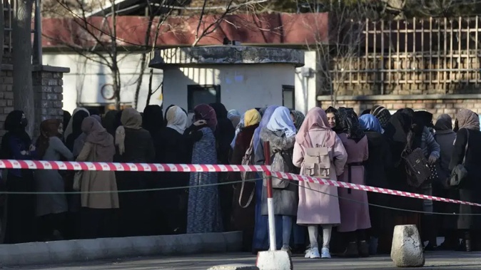 Afghan students queue at one of Kabul University's gates in Kabul, Afghanistan in February 2022. Photo / AP