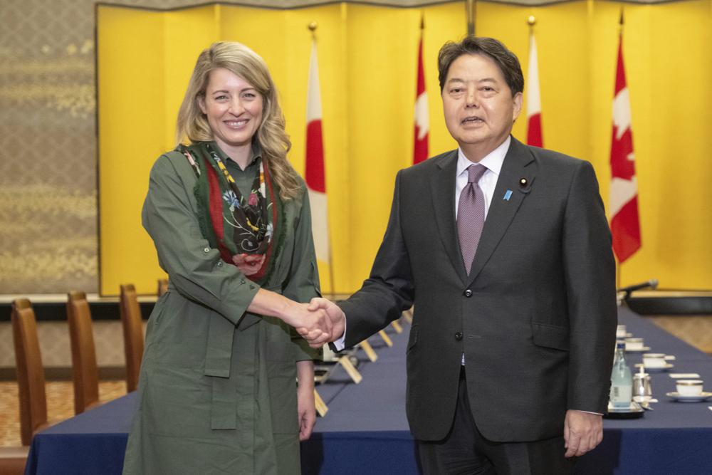 Canadian Foreign Minister Melanie Joly and Japanese Foreign Minister Yoshimasa Hayashi shake hands prior to their meeting at the Iikura Guest House in Tokyo, Tuesday, Oct. 11, 2022. (Yuichi Yamazaki/Pool Photo via AP)