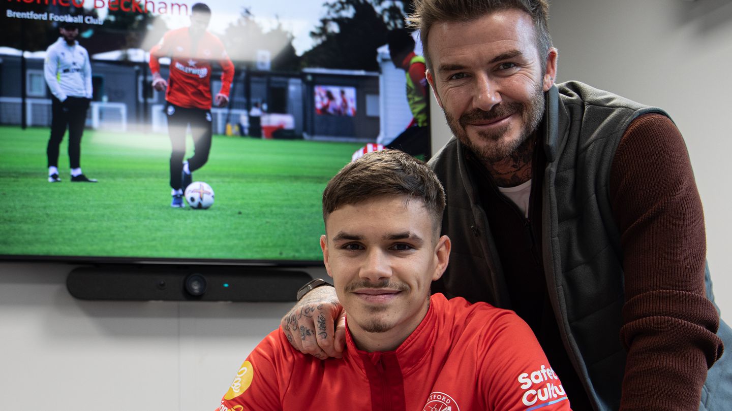 Romeo Beckham signs his contract with Brentford under the supervision of his father, David. Photo / Brentford FC