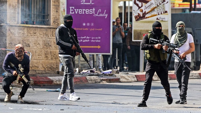 Palestinian armed militants take up positions during a clash with Israeli forces in Jenin on Monday. Jaafar Ashtiyeh/AFP/Getty Images