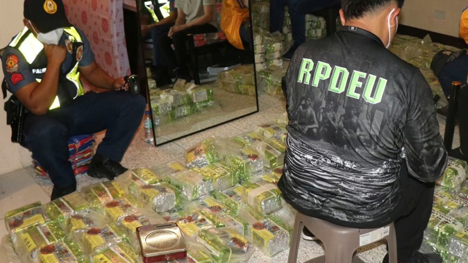 Police officers inspect tea bags containing suspected methamphetamine during a raid at a house in Baguio city, northern Philippines. Photo / AP