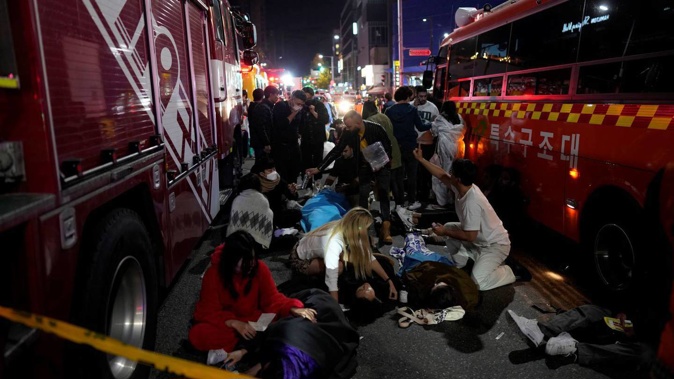 Injuried people are helped on the street near the scene in Seoul, South Korea, early on Sunday. Photo / AP