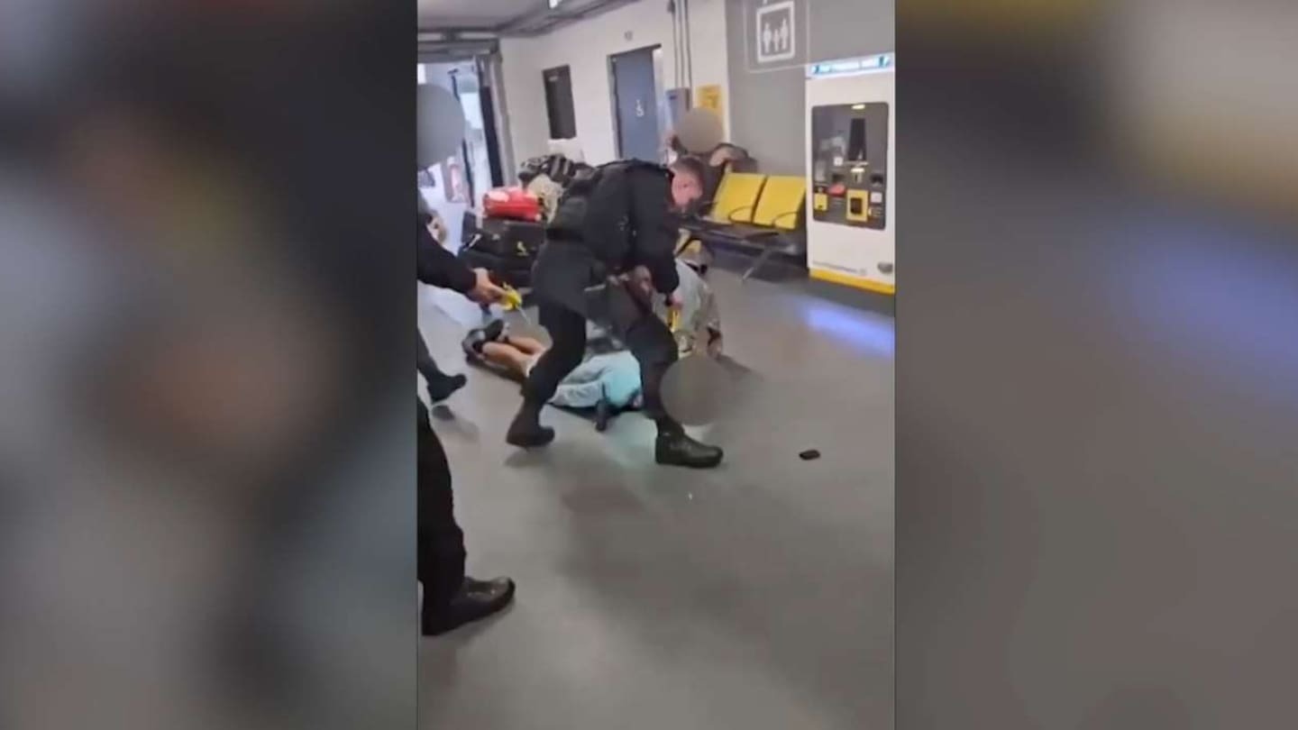 An armed police officer was filmed apparently stamping on a man’s head at Manchester Airport in the UK. Photo / YouTube