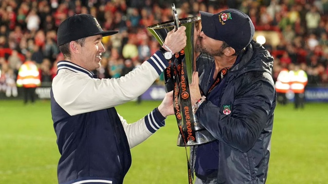 Wrexham co-owners Rob McElhenney, left, and Ryan Reynolds celebrate with the trophy after their team clinched promotion. Photo / AP