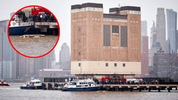 Police and firefighters work on the site after a helicopter crashed in the Hudson River earlier today. Photo / AFP