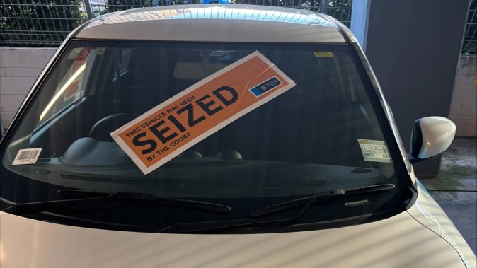 The courts seized an Auckland Council car for unpaid fines. Pictured is the car emblazoned with stickers and was clamped. Photo / Riley Kennedy