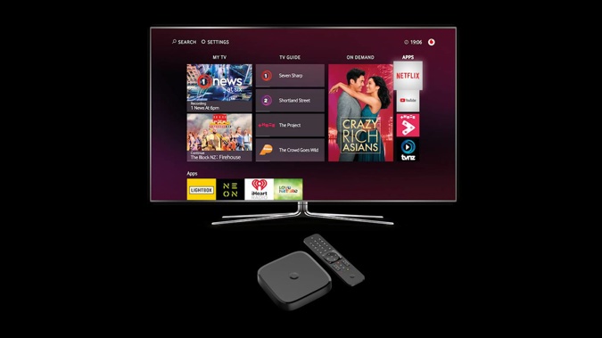 A Vodafone TV box and remote (foreground). The service delivers Sky and free-to-air channels over UFB fibre or cable, eliminating the need for a Sky dish, and supports apps like Netflix.