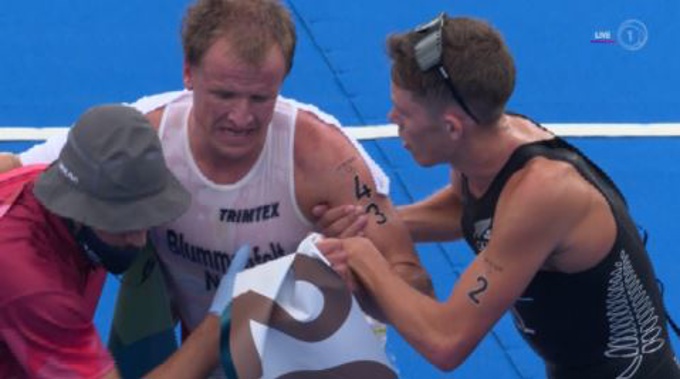 Hayden Wilde helping Kristian Blummenfelt to his feet. Photo / TVNZ/Sky Sport