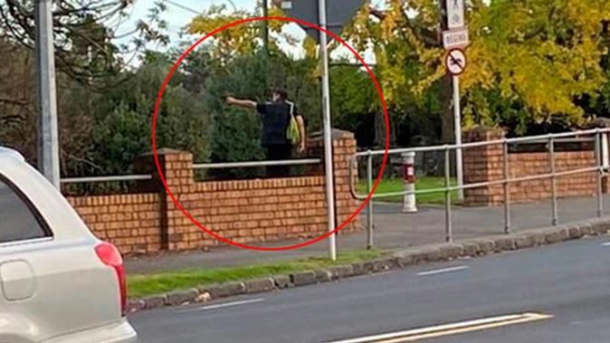 Man pictured pointing what appears to be a handgun on the grounds of Auckland's Unitec this morning. (Photo / Supplied)