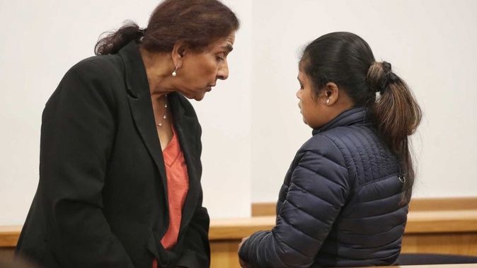 Ritika, right, stands with her back to the courtroom as she appears for sentencing in the Auckland District Court. An interpreter stands on the left. (Photo / Jason Oxenham)