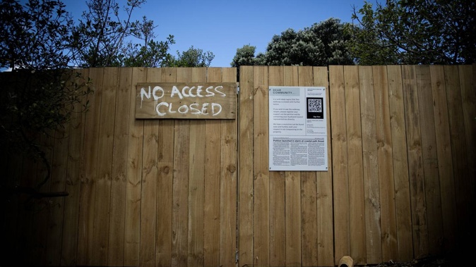 A sign warning people not to use the rocks where part of a popular beach path has been closed to the public. Photo / Dean Purcell