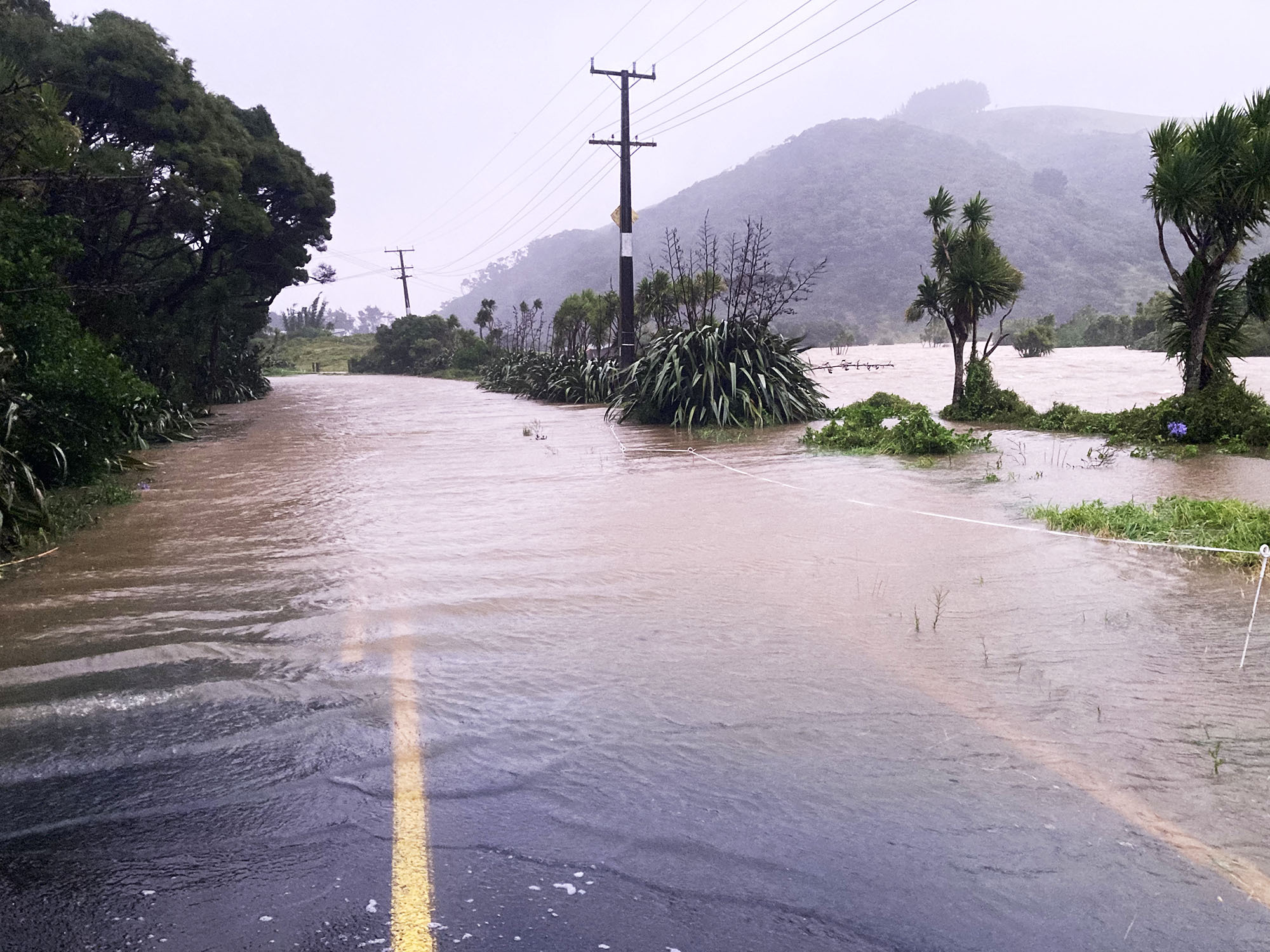 Bethells Road is blocked by flooding. Photo / Michael Craig