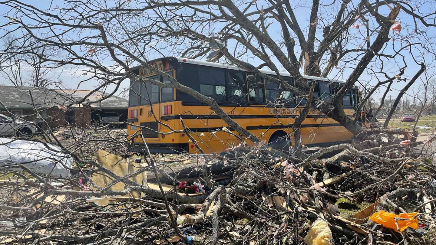 A bus passes debris in Mississippi were several people have been killed by tornadoes. Photo / AP