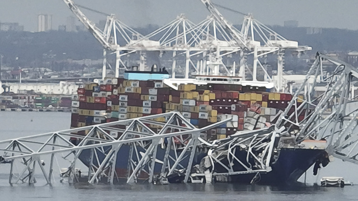 A cargo ship is stuck under the part of the structure of the Francis Scott Key Bridge after the ship hit the bridge. Photo / AP