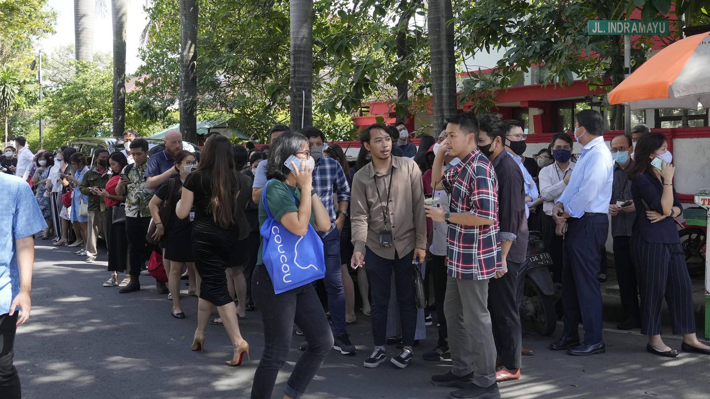 People wait outside an office building after being evacuated following an earthquake at the main business district in Jakarta, Indonesia. Photo / AP