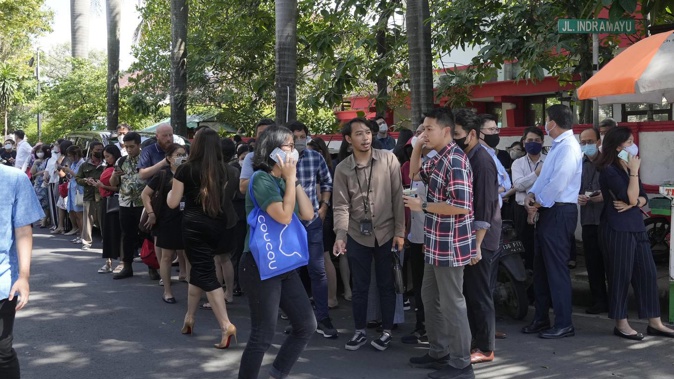 People wait outside an office building after being evacuated following an earthquake at the main business district in Jakarta, Indonesia. Photo / AP