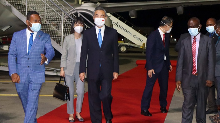 China's Foreign Minister Wang Yi, center, is escorted from his plane on his arrival in Honiara, Solomon Islands, early Thursday, May 26, 2022. (Photo / AP)
