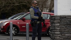 An armed police officer stands guard outside Rutherford College, which is in lockdown. Photo / Hayden Woodward