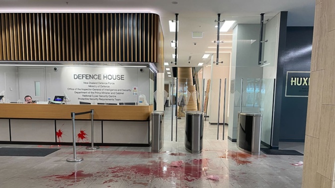 A red substance was thrown by protesters around Defence House in Wellington this morning. Photo / Julia Gabel