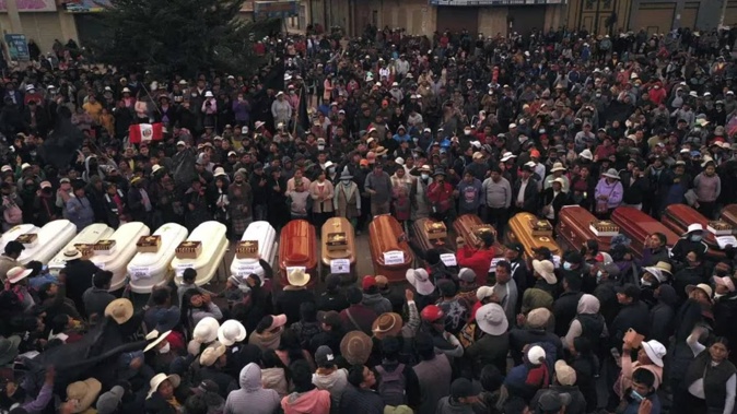 Residents surround coffins during a vigil for the more than a dozen people who died during the unrest in Juliaca, Peru. Photo / AP