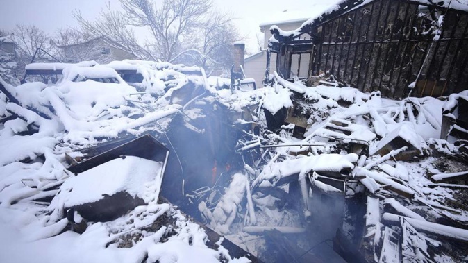 An overnight dumping of snow and frigid temperatures compounded the misery of hundreds of Colorado residents who started off the new year trying to salvage what remains of their homes. (Photo / AP)