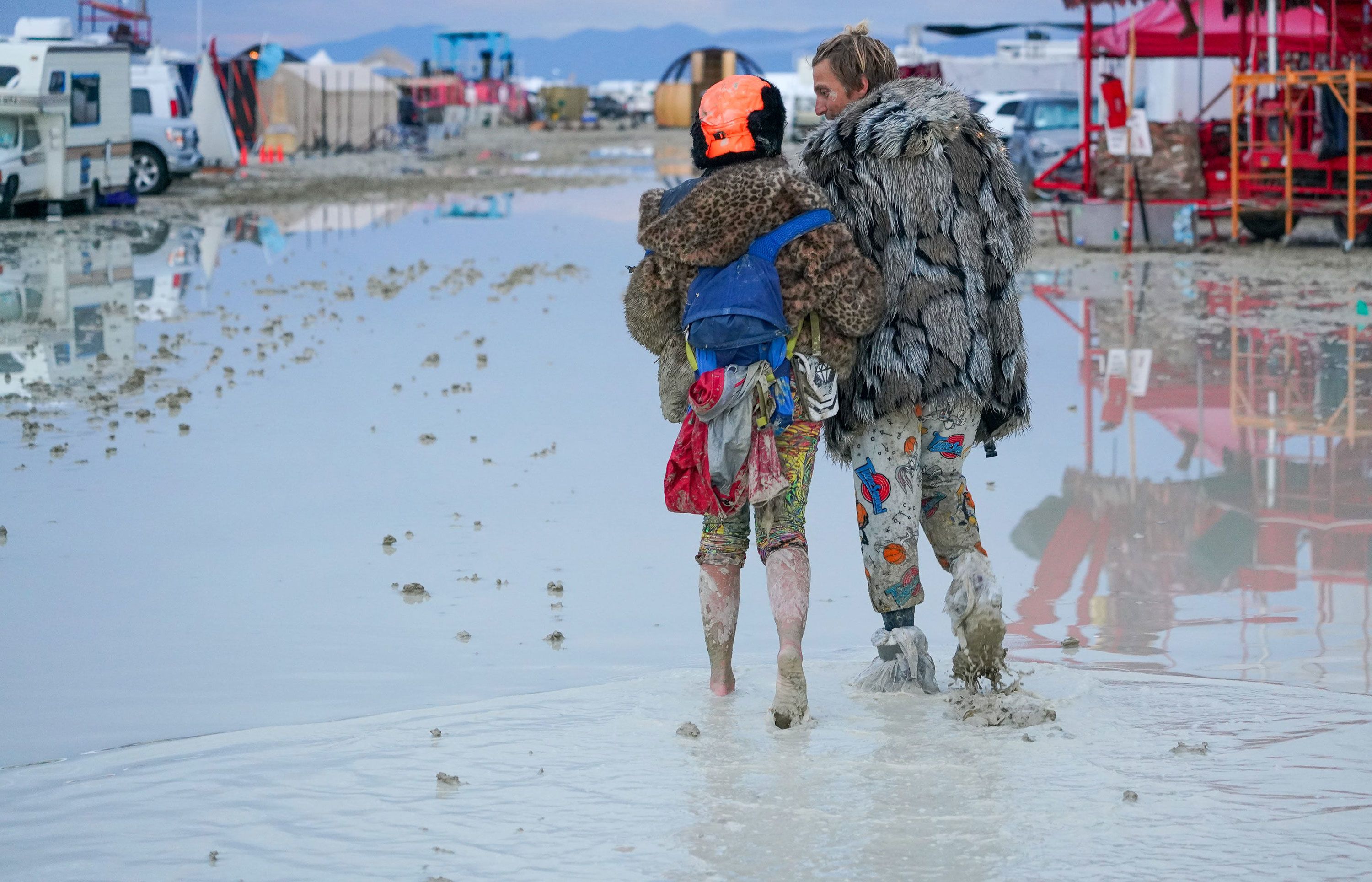 Burning Man attendees walk through the mud on September 2. (Photo / CNN)