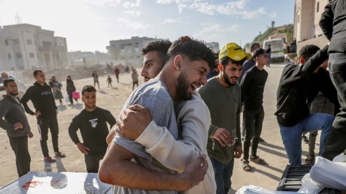 A Palestinian man is comforted as he weeps next to a truck carrying the bodies of the victims of Israeli airstrikes in northern Gaza for burial in March. Photo / AFP file