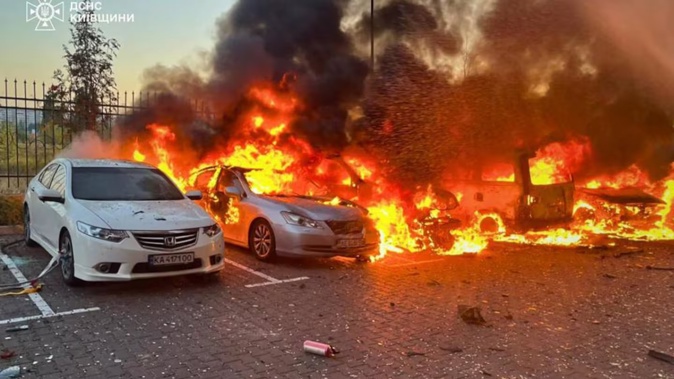 Burning cars in a parking lot following an air attack at an undisclosed location in the Kyiv region, amid the Russian invasion of Ukraine. Photo / Handout, Ukrainian Emergency Service, AFP