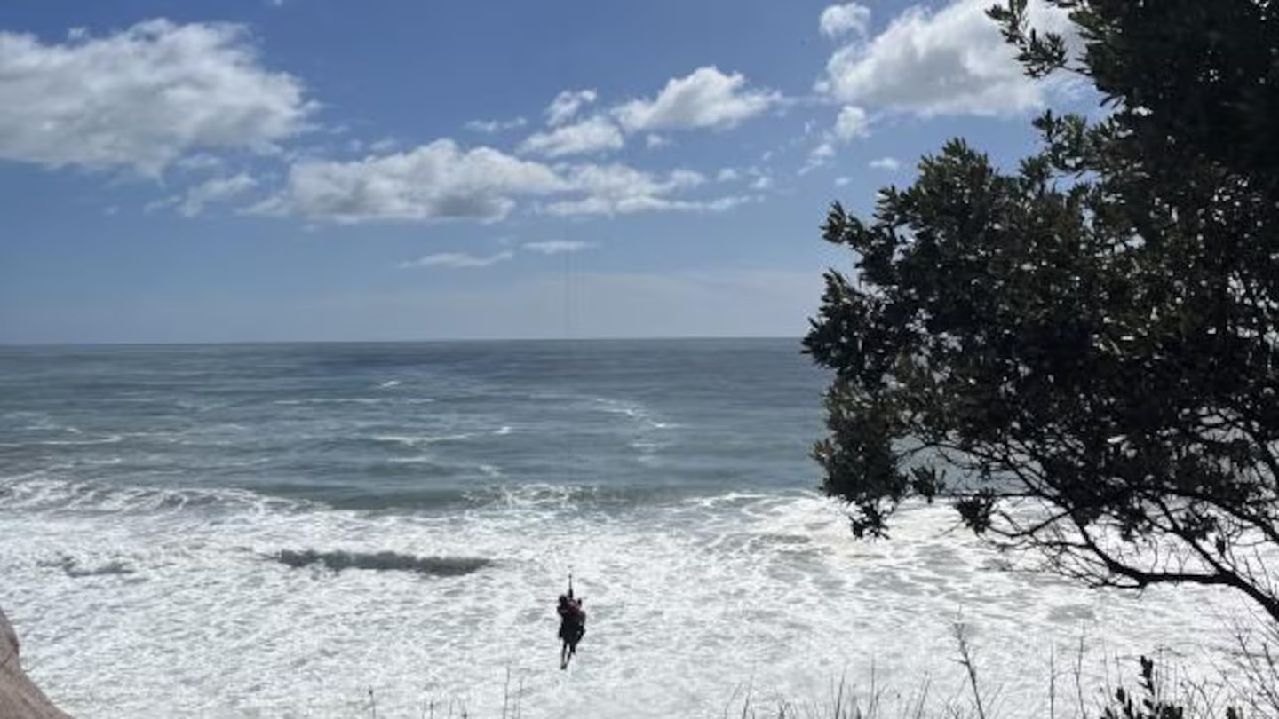 Two people visiting the Whiritoa Beach blowhole got caught out by the big surf and incoming tide this morning.