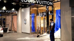 A police officer stands outside the Louis Vuitton and Gucci stores in downtown Auckland. (Photo / Hayden Woodward)