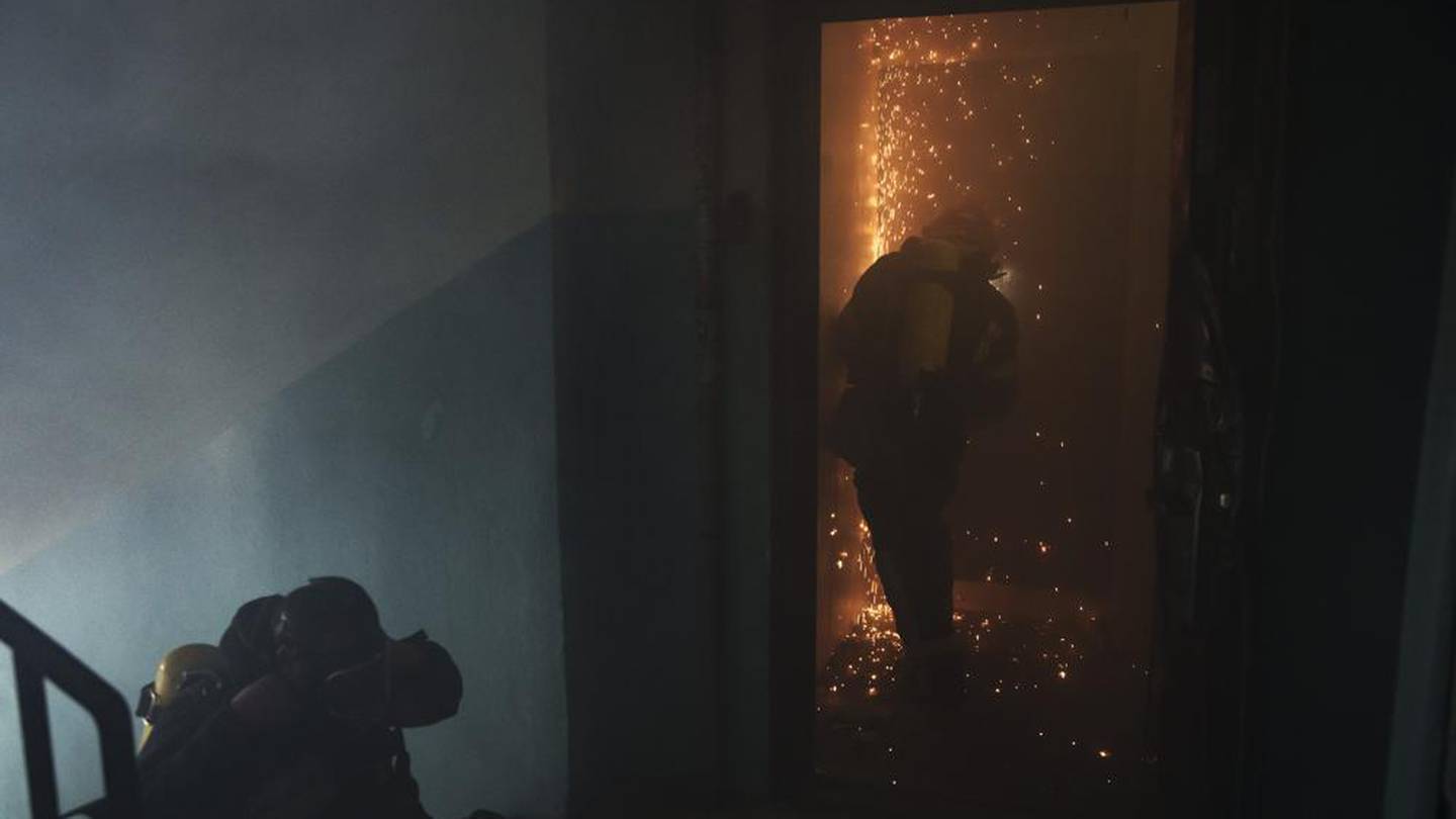 A firefighter opens the door of a burning apartment after a Russian bombardment in Kharkiv, Ukraine, Thursday, April 21, 2022. (Photo / AP)
