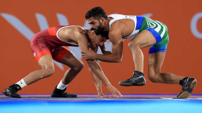 New Zealand's Suraj Singh (left) in action against Pakistan's Ali Asad in the men's 57kg bronze medal match. Photo / Getty